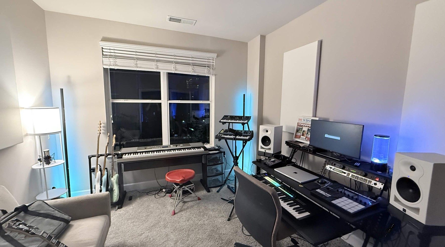 Home studio with monitors, controllers, guitars, and recording gear